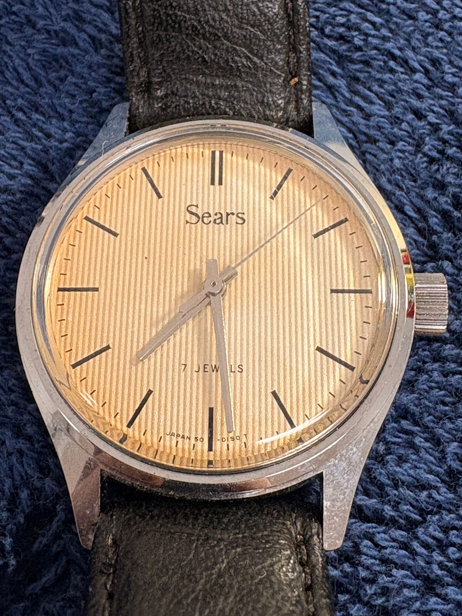 Vintage Sears Hand-Wind Mechanical Wristwatch (7 Jewels): Vintage Sears manual wind wristwatch featuring a textured champagne dial with minimalist baton markers and center seconds. Marked “7 Jewels” and “Japan” at dial base. Stainless steel