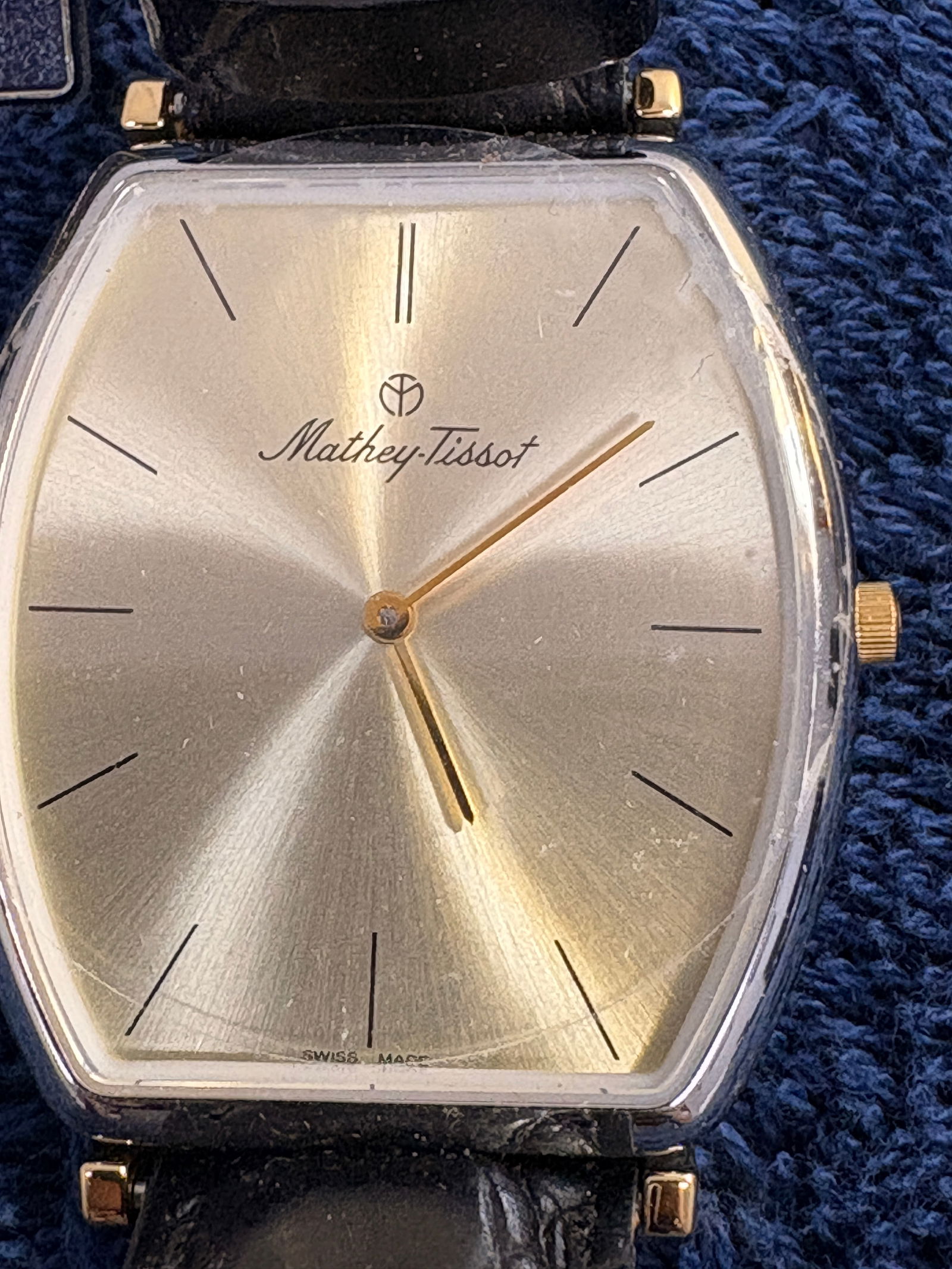 Mathey-Tissot Genève Tank-Style Gold Tone Quartz Wristwatch: Elegant vintage Mathey-Tissot Genève wristwatch featuring a classic tonneau/tank-style gold-tone case with sunburst champagne dial and minimalist baton hour markers. Swiss quartz movement. Black