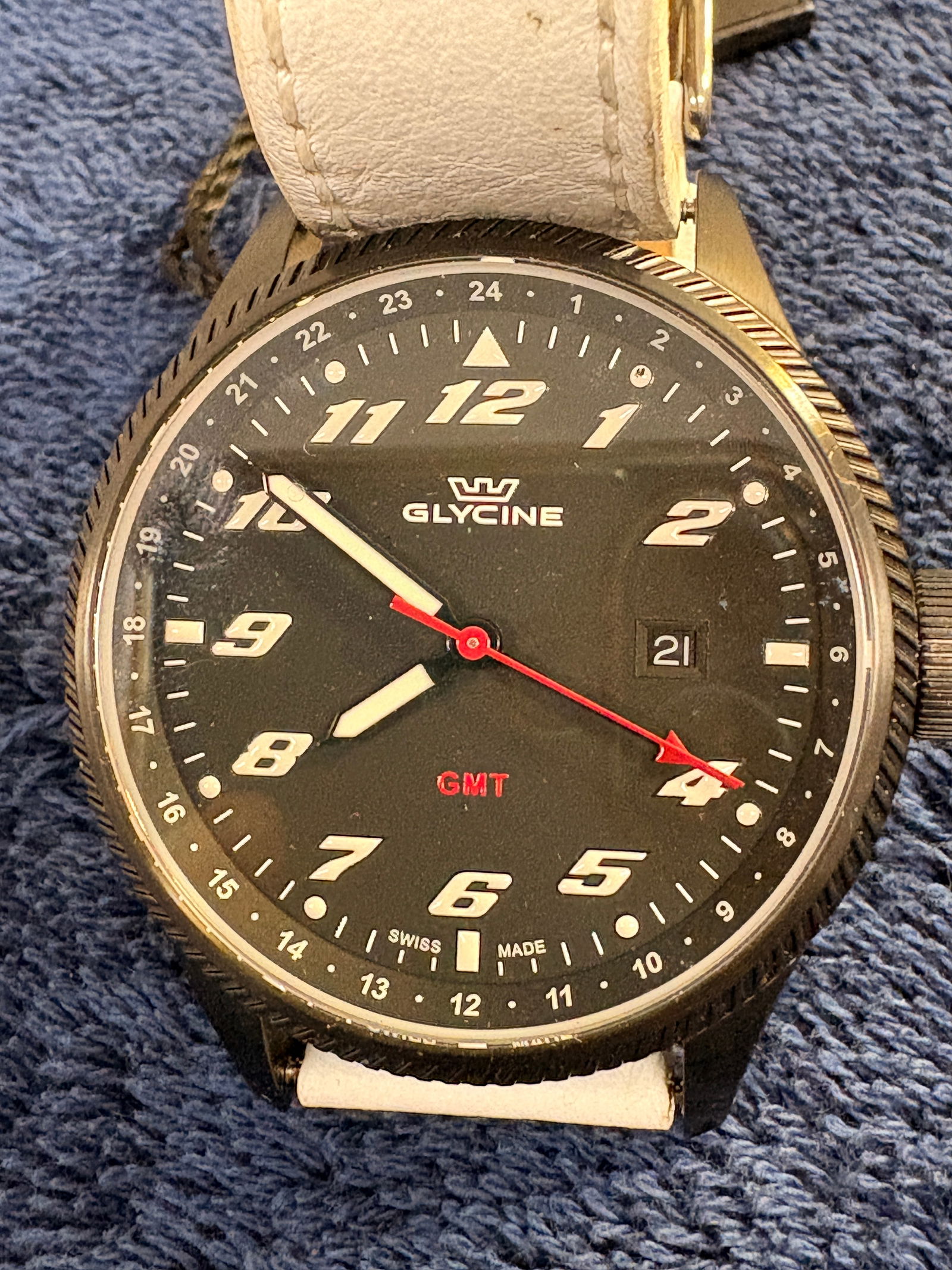 Glycine Airman-Style GMT Black Dial Watch: Glycine GMT wristwatch with black dial, red GMT hand, and date display. Swiss made. Leather strap. Quartz movement. Approx. 42mm case. Good condition with minor wear.