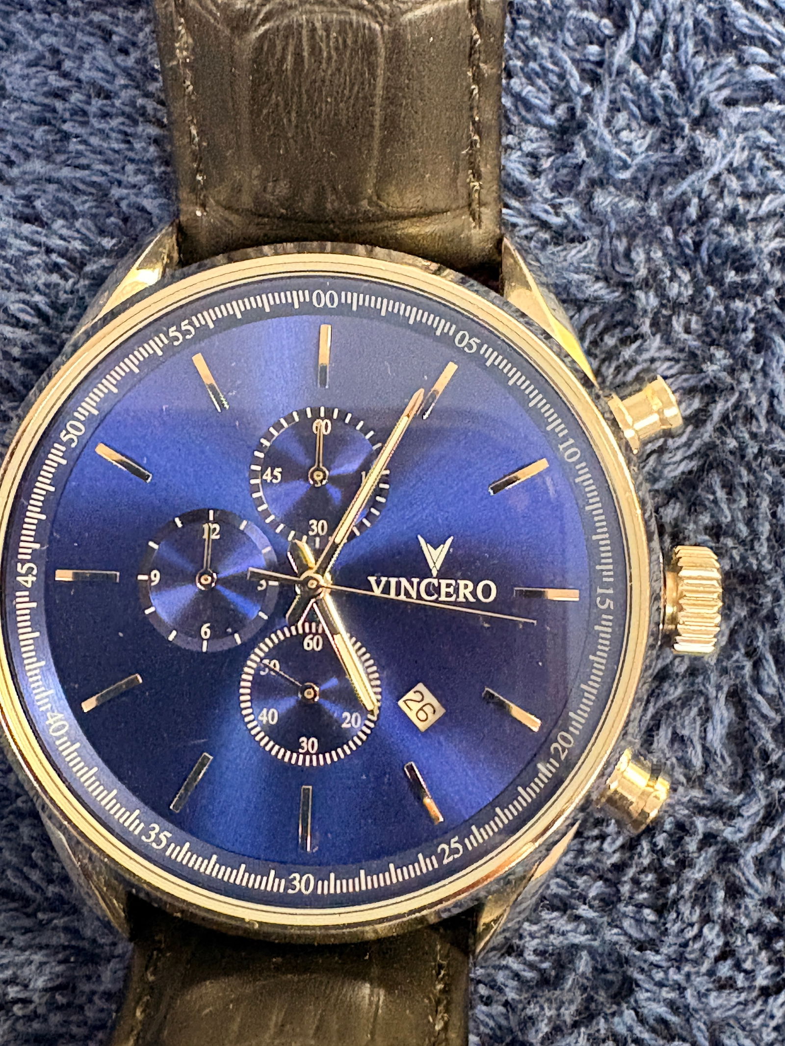 Vincero Blue Dial Chronograph Wristwatch: Modern Vincero men’s chronograph wristwatch featuring a deep blue sunburst dial with three subdials, date display, and gold-tone case. Fitted with black leather strap. Japan movement. Light wear