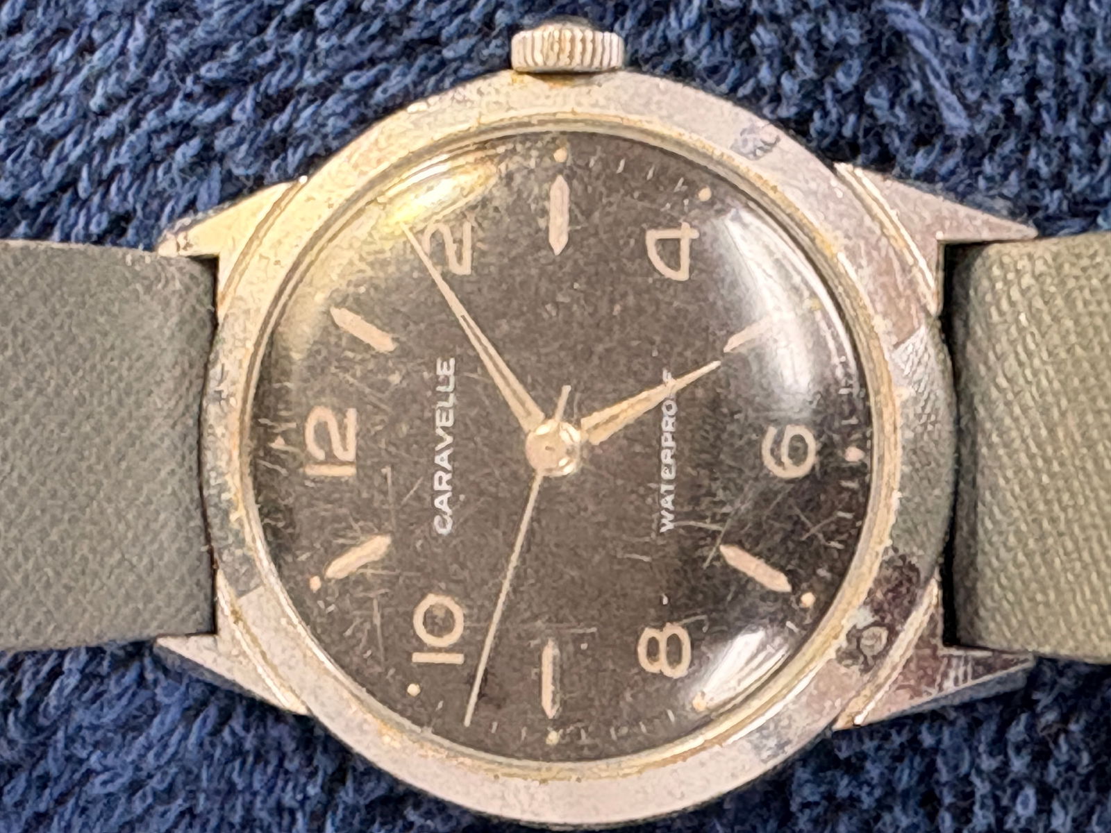 Caravelle by Bulova Vintage Manual Wind Wristwatch: Classic mid-century Caravelle by Bulova wristwatch featuring a black dial with Arabic numerals and manual wind movement. Stainless steel back with gold-tone case shows honest vintage wear and patina