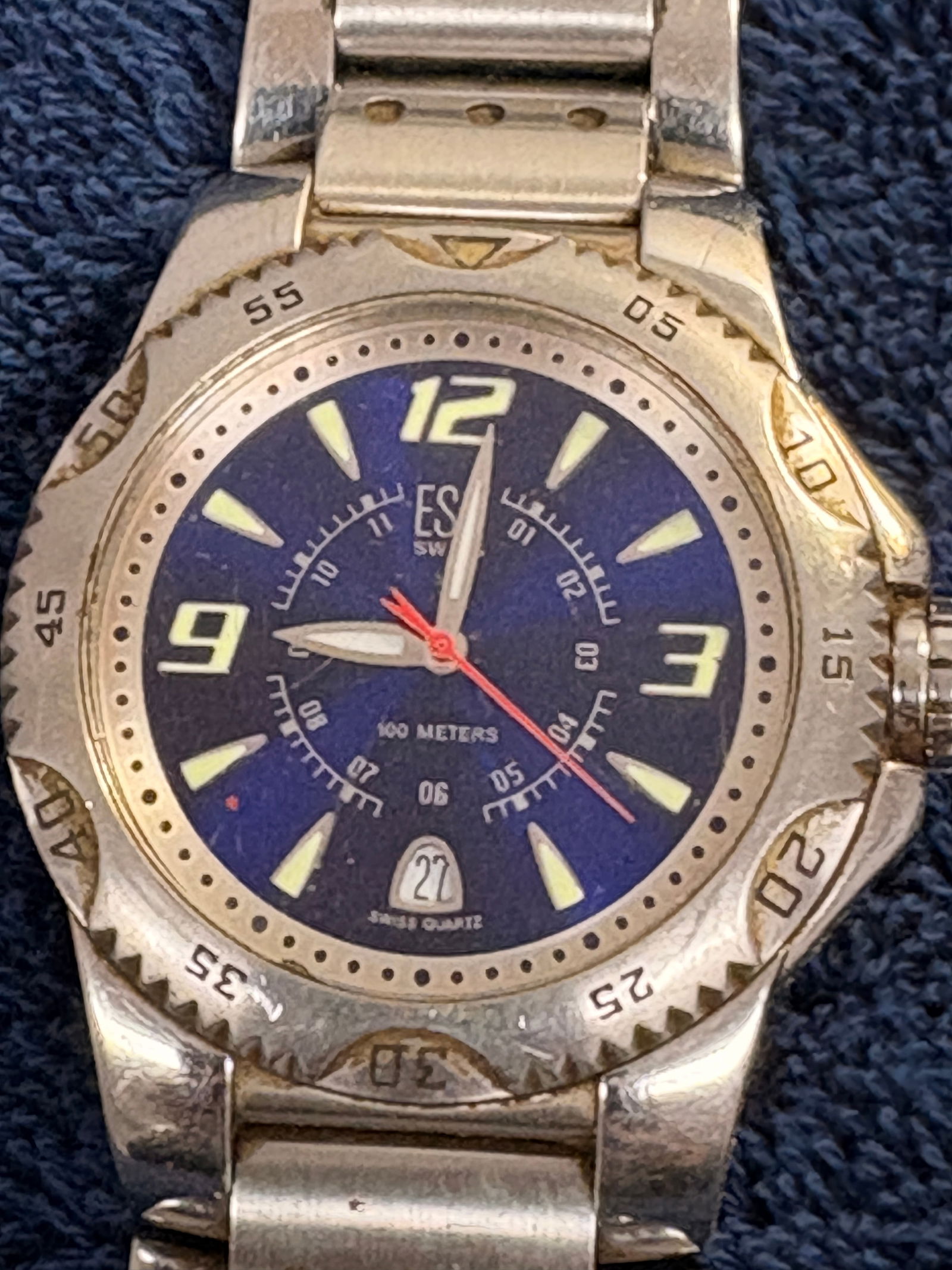 ESQ Swiss 100M Blue Dial Diver-Style Quartz Wristwatch: Sporty ESQ Swiss quartz watch with blue dial, luminous markers, rotating diver-style bezel, and date at 6. Rated 100 meters water resistant. Stainless steel case and bracelet. Shows moderate wear.