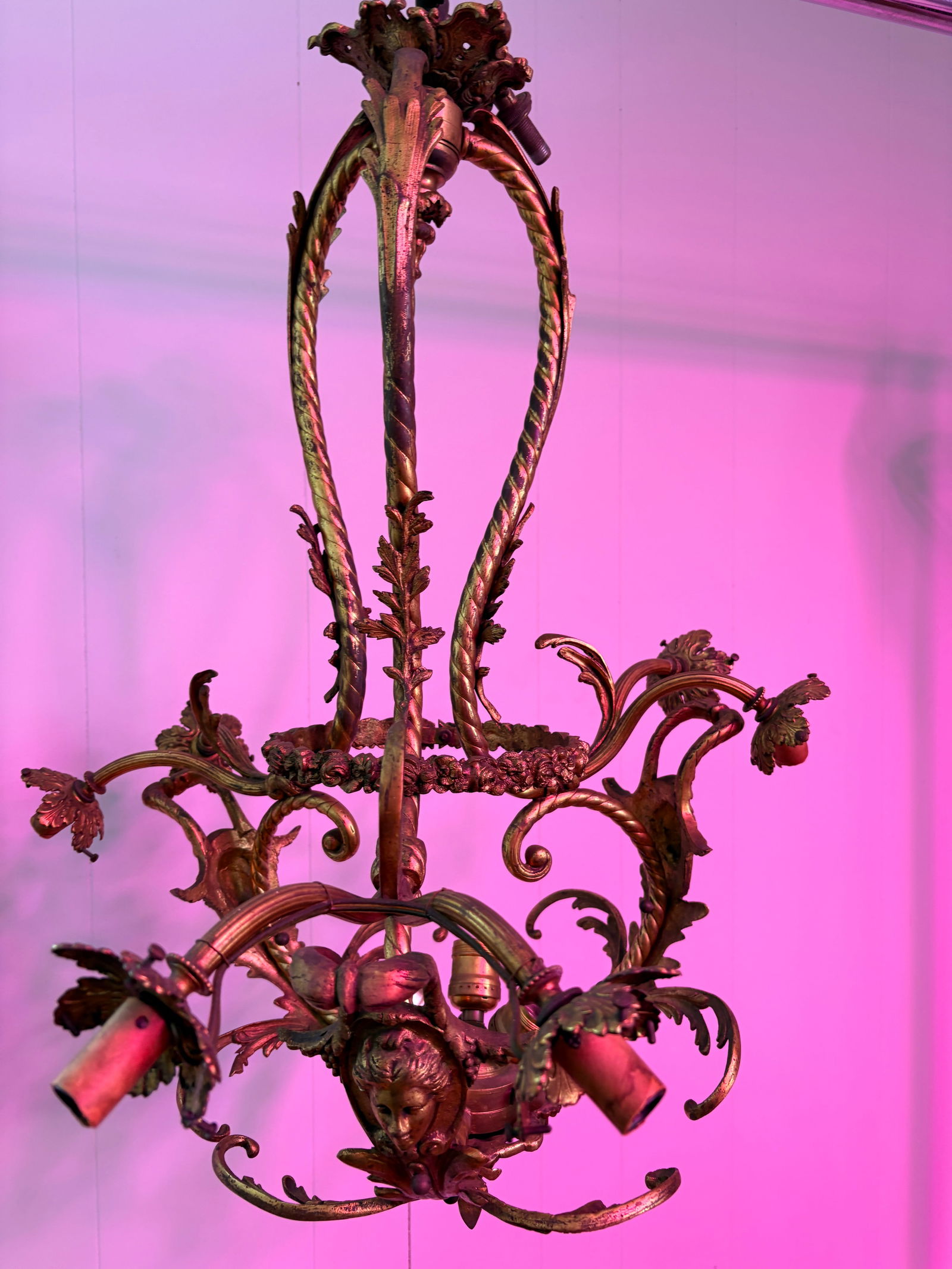 Antique French Gilt Bronze Cherub Chandelier: Authentic antique French chandelier crafted from solid bronze with original gilt patina. Features ornate Rococo foliate arms and a detailed cherub (putti) mask at the center. Very heavy, finely bronze