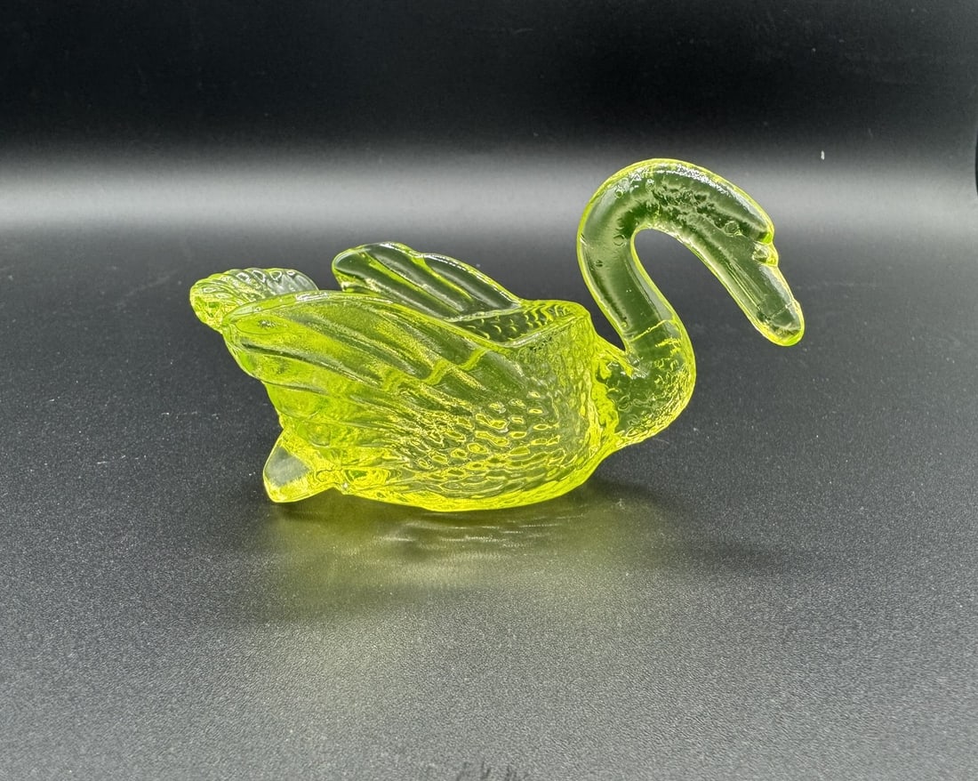 Mosser Glass Uranium Vaseline Glass Swan Trinket Dish: This is a beautiful vintage Vaseline glass swan trinket dish produced by Mosser Glass, a renowned American glassmaker. Molded in a graceful swan shape with detailed wings, tail feathers, and textured 