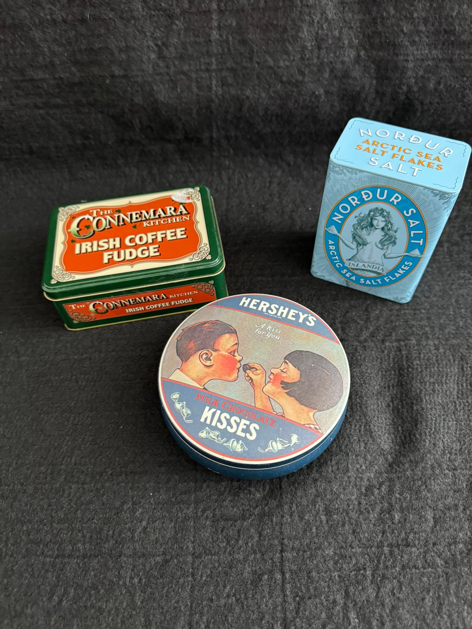 Lot of 3 Decorative Food Tins – Hershey’s Kisses (1982), Connemara Irish Coffee Fudge,: This charming trio of collectible tins offers nostalgic appeal and international flair:Hershey’s Kisses Tin (1982) – A circular tin made in England, marked “Copyright © 1982 Hershey Foods Corp.