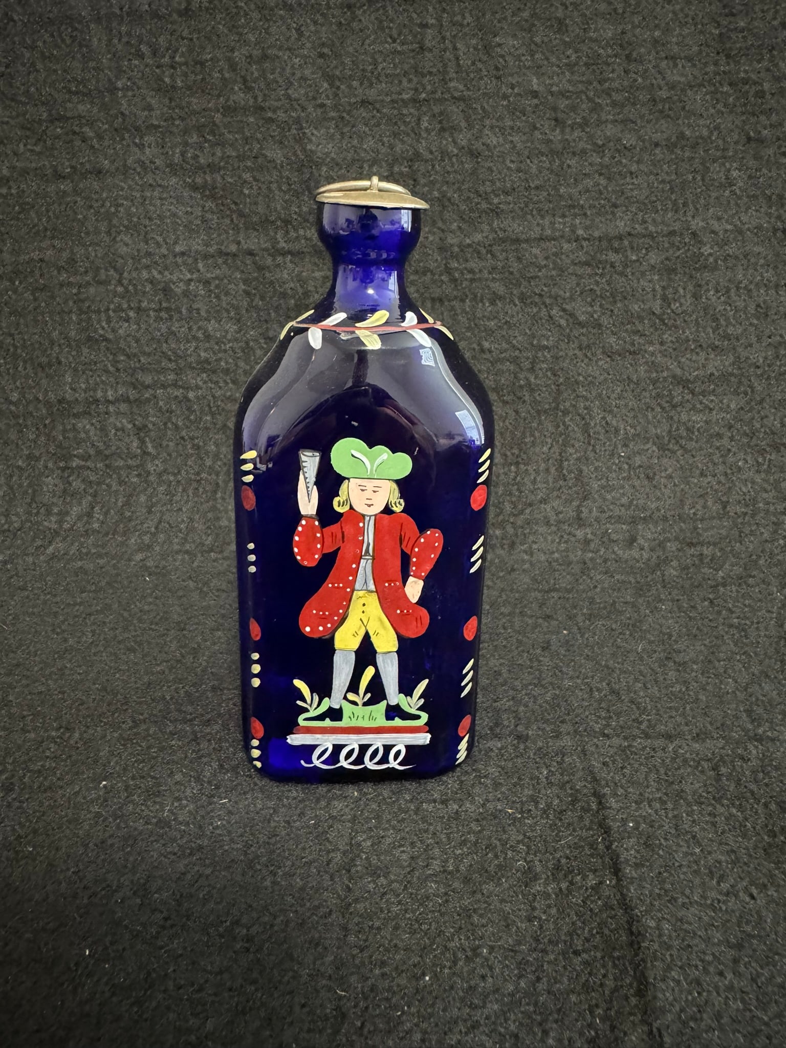 Antique Hand-Painted Cobalt Glass Flask with Folk Figure: Antique Hand-Painted Cobalt Glass Flask with Folk Figure – Pontil Scar Base (6") A striking cobalt blue glass flask featuring a charming hand-painted figure in 18th-century attire, flanked by decora