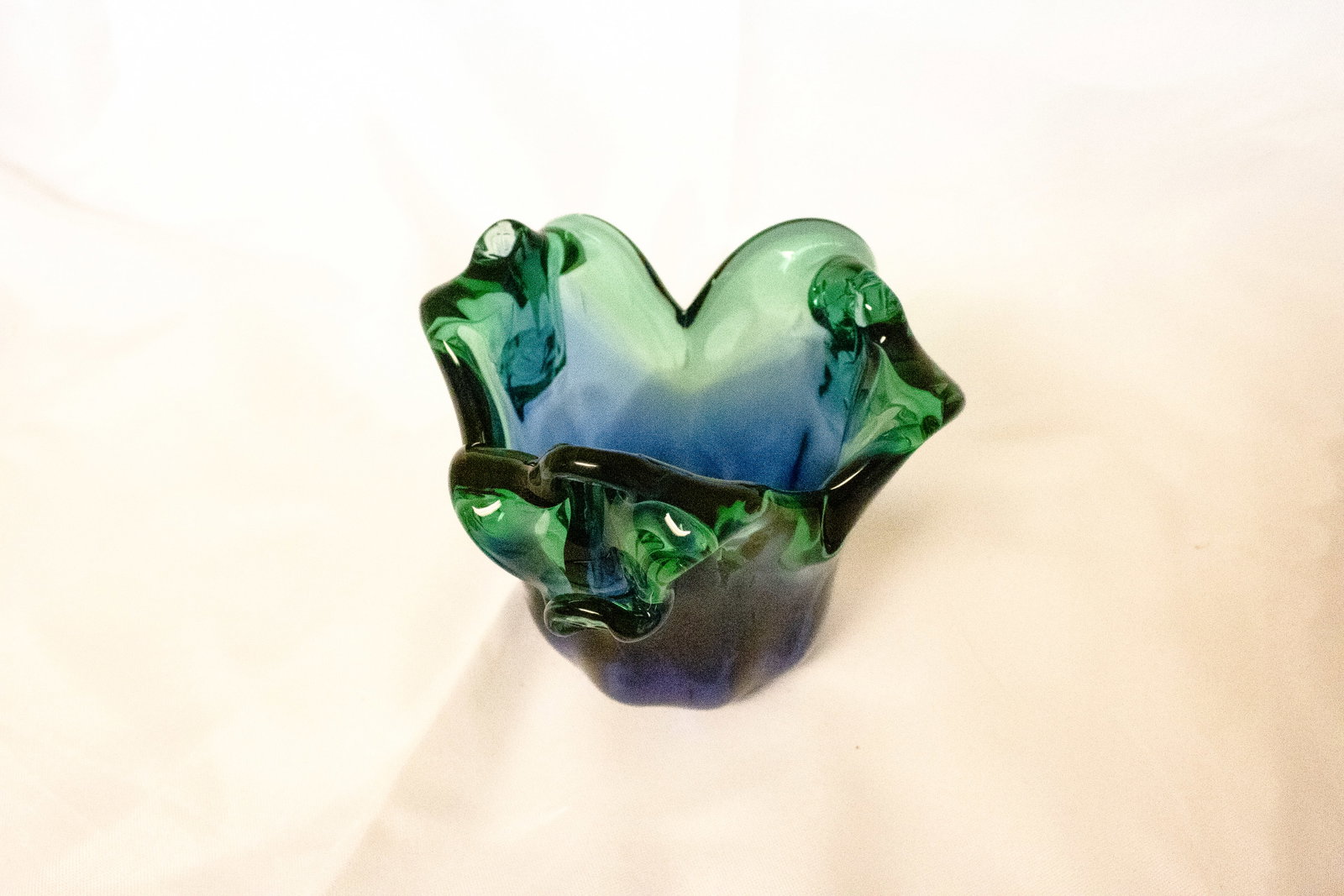Murano Blue and Green Glass Bowl: A stunning example of Italian glass artistry, this Murano glass bowl features vibrant hues of blue and green that blend seamlessly in a fluid, organic form. Hand-blown by skilled artisans on the islan