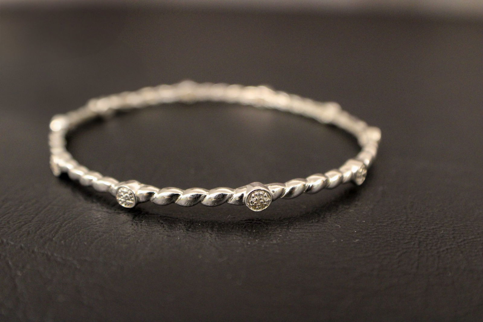 Sterling Silver Bangle with Satellite Diamonds: This elegant sterling silver bangle is accented with sparkling satellite diamonds, adding just the right touch of brilliance. The minimalist yet sophisticated design makes it ideal for layering or wea