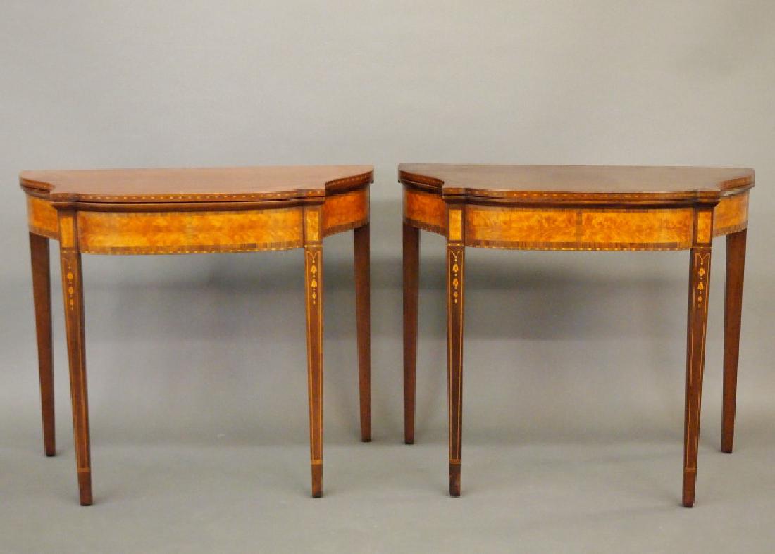 Pr Hepplewhite style games tables: A pair of mid 20th century American Hepplewhite style Mahogany games tables. Each has a hinged serpentine top with conforming skirt and Flame Birch panels, all raised on square tapering supports adorn