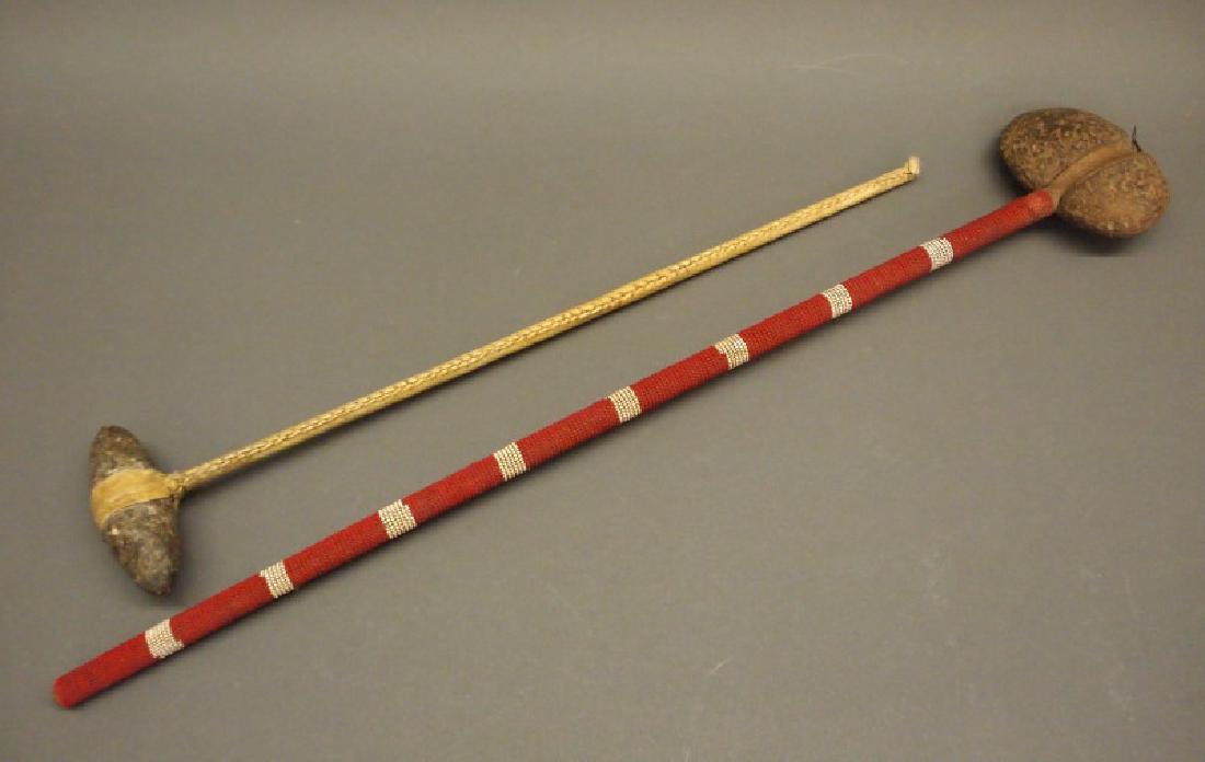 2 Plains stone & bead club: Two Plains bead and rawhide clubs. Including 1 mid 20th century beaded skull cracker club, the wood shaft adorned with red and white beads, fitted with a rounded stone head wrapped with rawhide at the