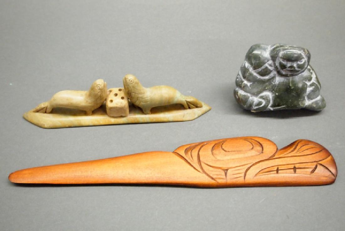 3 Inuit/Northwest Coast carvings: Three Inuit and Northwest Coast carvings. Inuit soapstone includes 1 group of two seals, and 1 figure with "Eskimo Art Canada" label underneath. Together with 1 cedar wood carving, signed "Sequilem St