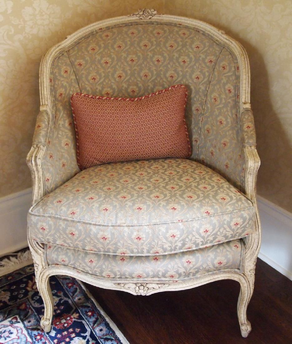 Louis XV style upholstered chair: A Louis XV style bergere. Antiqued white frame, upholstered back, padded arms and loose seat cushion, with an accent pillow. Minor wear. 36" high. ESTIMATE $200-300