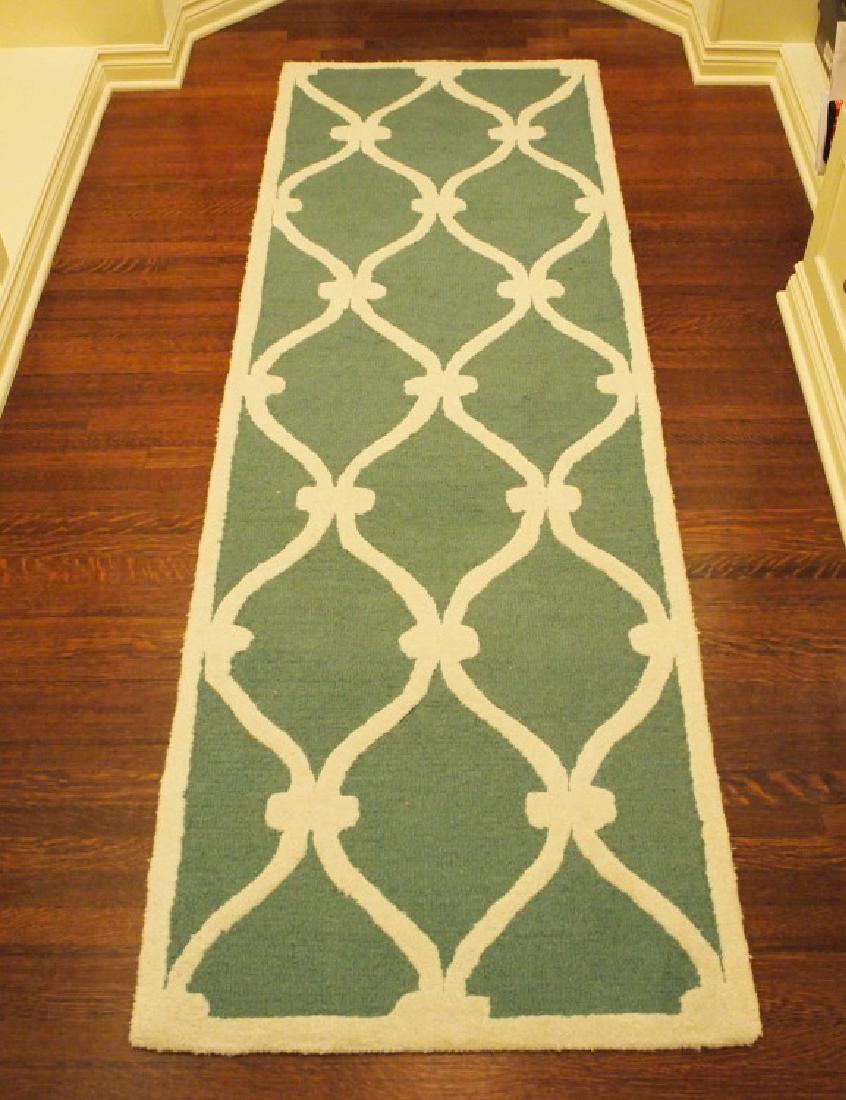 Lattice pattern accent rug: A 7.10 x 2.7' contemporary rug. A white lattice pattern on an aqua ground. Minor wear. ESTIMATE $50-100