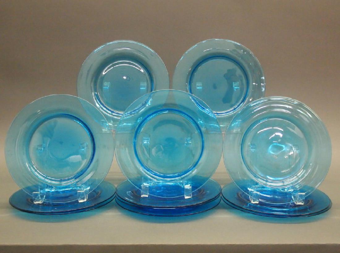 12 Steuben Celeste Blue plates: A set of twelve Steuben glass plates, circa 1920. Celeste Blue, each bears the acid-stamped fleur de lis mark. A few light scratches, small and minor nicks to a foot ring; overall, good condition. 8 1