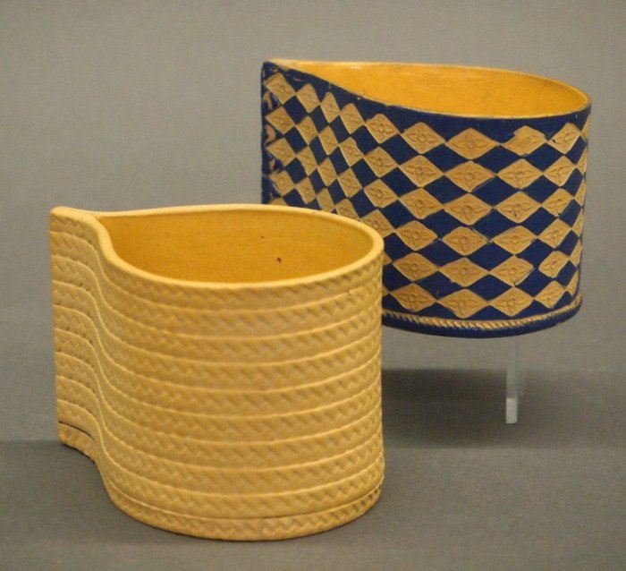 Wedgwood teardrop custard cups: Two late 18th century Wedgwood Ornamented Caneware custard cups. In rare teardrop (pear) shape, one of which is heightened with blue enamel; both are glazed at the interior. Unmarked except for the bl