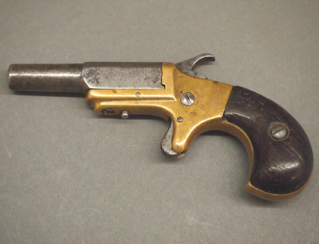 Marlin First Model Deringer with Sewing Box: A Marlin First Model Deringer concealed in a Sewing box. 22 caliber, single shot pistol. Part round/part octagon barrel swings sideways for loading and is stamped "J. M. MARLIN/NEW HAVEN, CT." on the