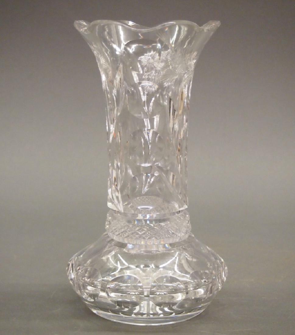 Libbey vase: A Libbey glass vase. Scalloped rim about the cylindrical neck and flared base, colorless with intaglio cut flower stems alternating with rows of circles. Acid-etched "Libbey" signature on the base. Ea