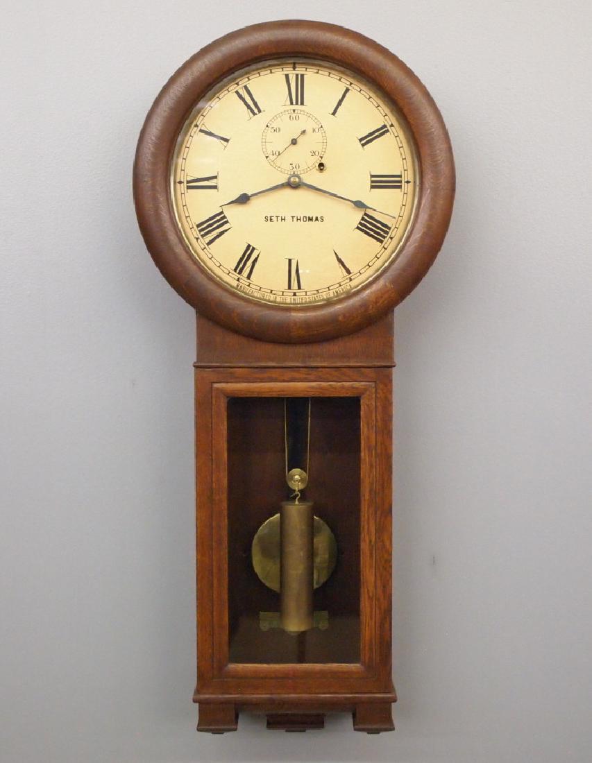 Seth Thomas No. 2 Regulator: An early 20th century Seth Thomas No. 2 Regulator wall clock. 8-day weight driven time only movement with painted metal dial and seconds bit. Oak case with round upper and rectangular lower doors. Old