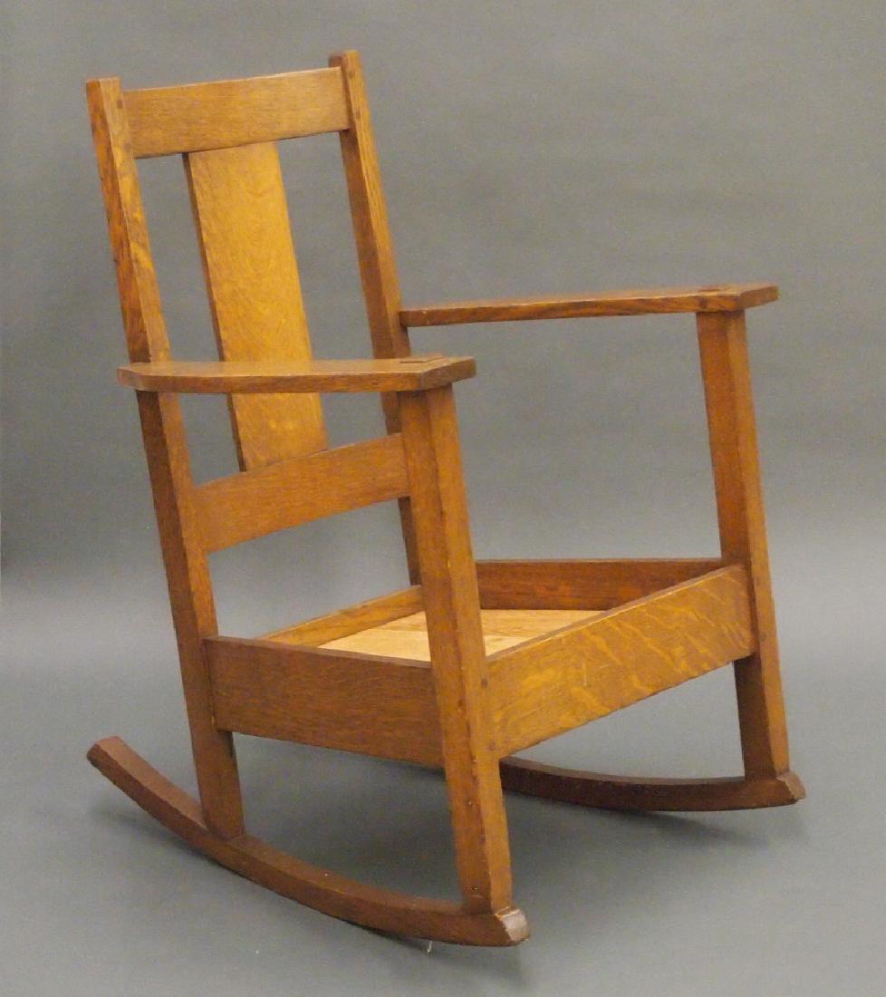 Limbert rocking chair: A Limbert Arts and Crafts Period Oak rocking chair #580. Square back with a single wide vertical splat, lift out seat and a stretcher base. Branded mark under arm. Older refinishing with minor wear, l