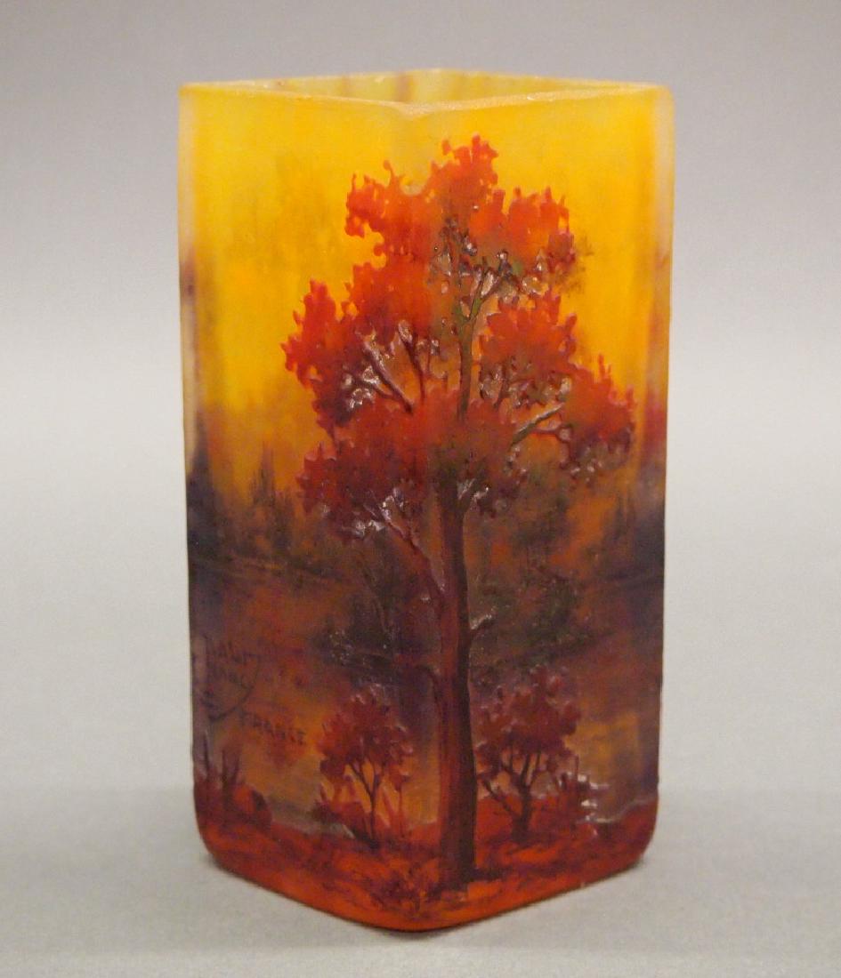 Daum Nancy Vase: A Daum Nancy Cameo Cut Glass Vase. Having Four paneled sides which display an Autumnal scene in matte shades of orange and red. Signed "Daum Nancy France" at one side. Some wear to the glass; possibly