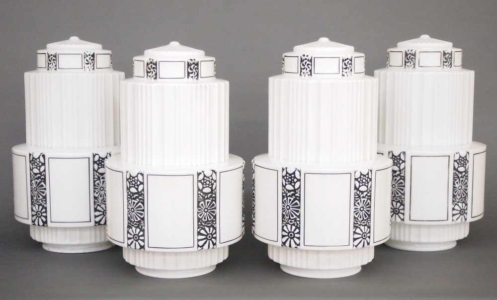 4 Art Deco Milk Glass Shades: Four Art Deco Milk Glass Shades. Molded bodies with paneled design and foliated detail highlighted in Black paint. Some wear and flakes in fitters. 6" fitters x 17" high. ESTIMATE $200-300