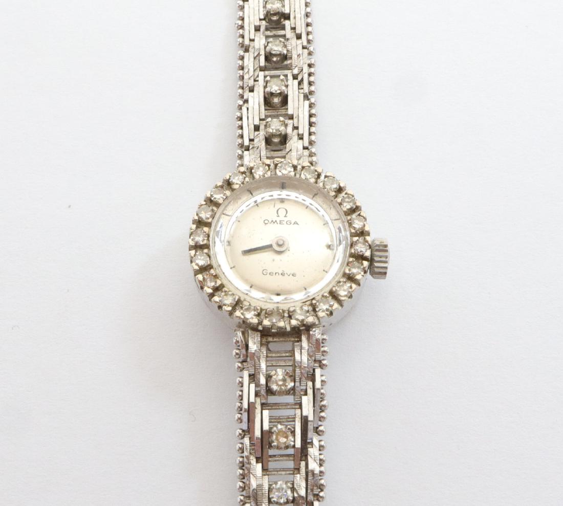 Vintage Omega Ladies Wristwatch: A Vintage Omega Ladies Wristwatch. Having diamonds encircling the round face and a white gold band with diamond accents. Stamped "18K 0750" on the back of the face, with "Omega Watch Co. Seventeen 17