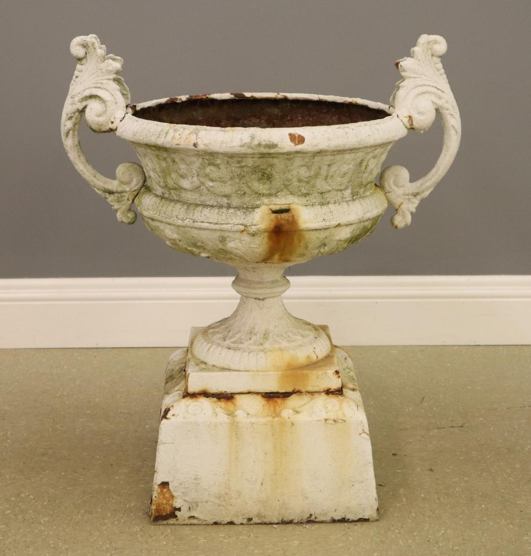Victorian Cast Iron Garden urn: A 19th century Victorian Cast Iron Garden Urn. Multi section construction with scrolled handles on a square plinth. Older re-paint with wear and some corrosion. 34" high overall. ESTIMATE $300-500