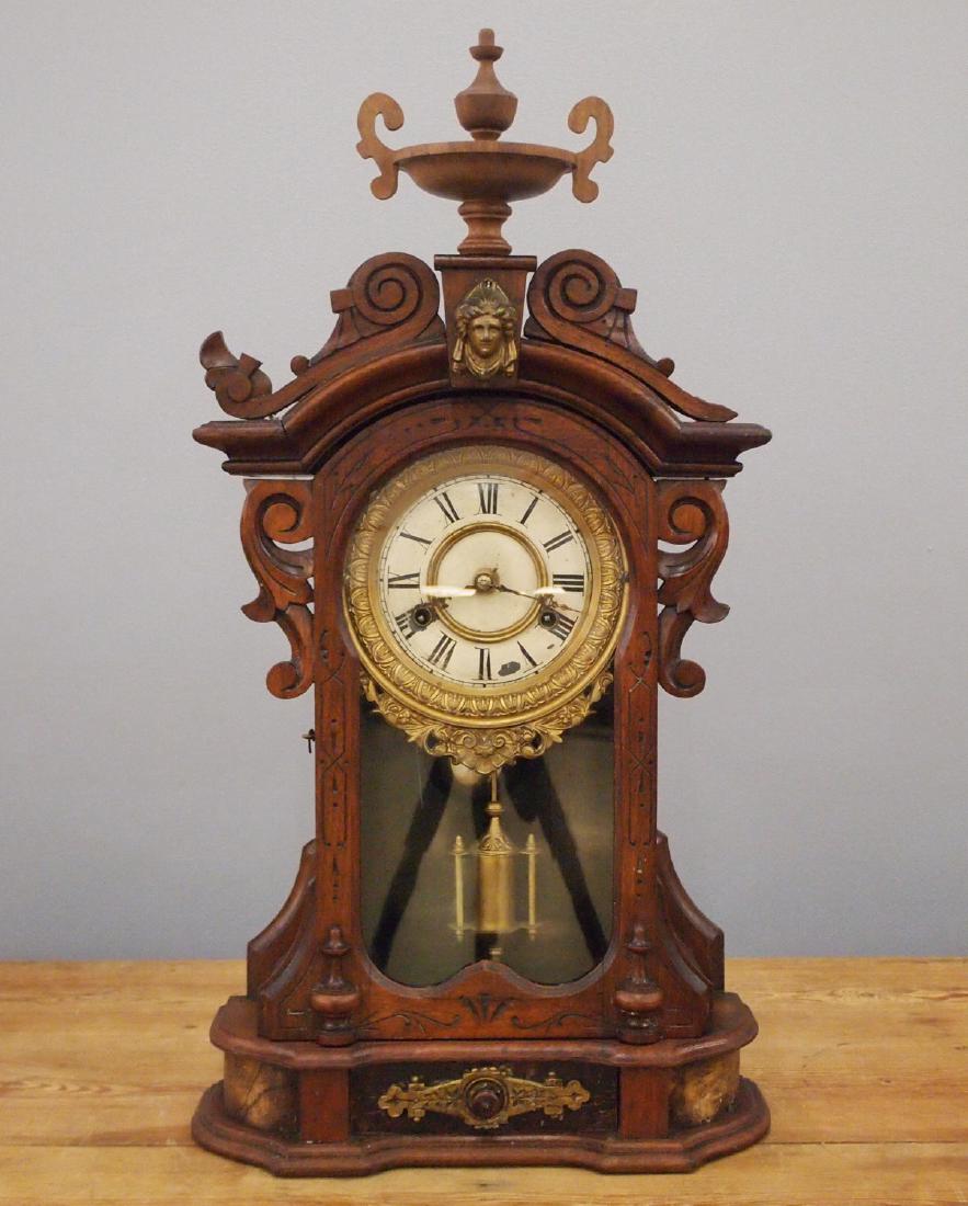 Ansonia "Monarch" shelf clock: A late 19th century Ansonia "Monarch" model shelf clock. 8-day spring driven time and strike movement with a painted metal dial and cast bezel. Walnut case with a pediment top and single arched door a