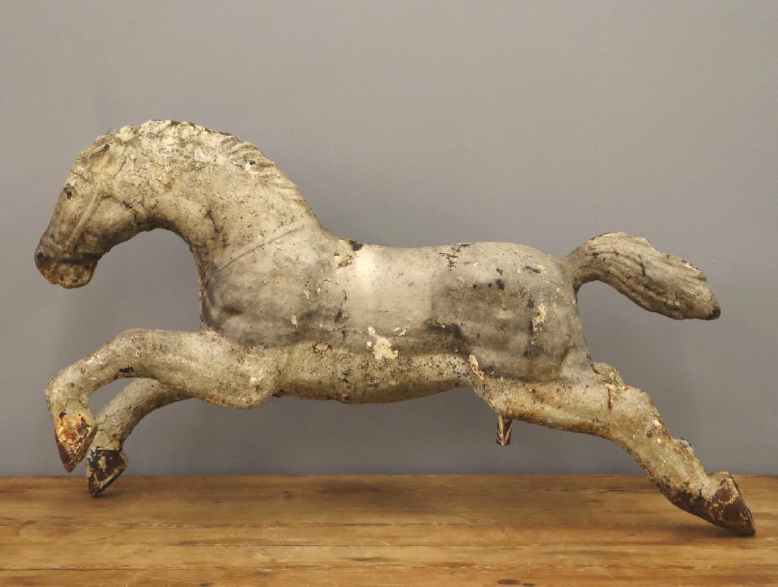 Cast Iron Carousel horse: A 1920's Cast Iron Carousel horse. Multiple layers of old, flaking paint, crack in casting at mane. 38" long x 22" high. ESTIMATE $200-300