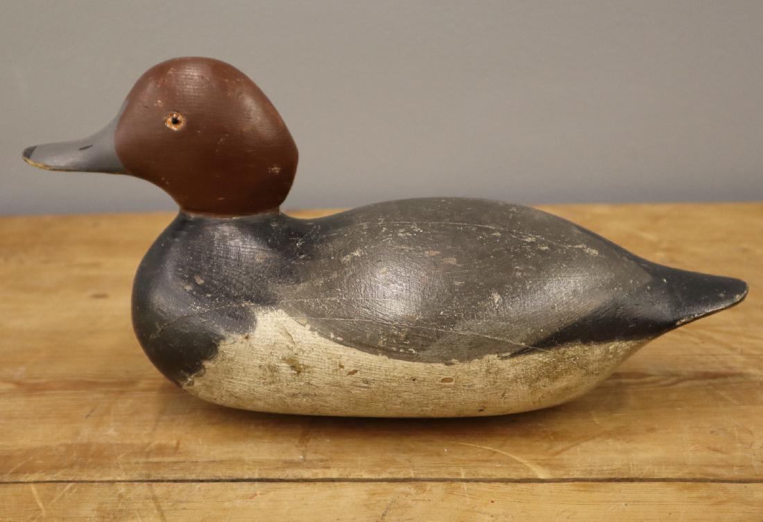 Mason Blue Bill Drake Decoy: A Mason Blue Bill Drake Decoy. Standard grade carved and painted wood decoy with red head, blue bill, and glass eyes, with "Raymond Lead" weight at the underside. Wear overall, some losses to the pain