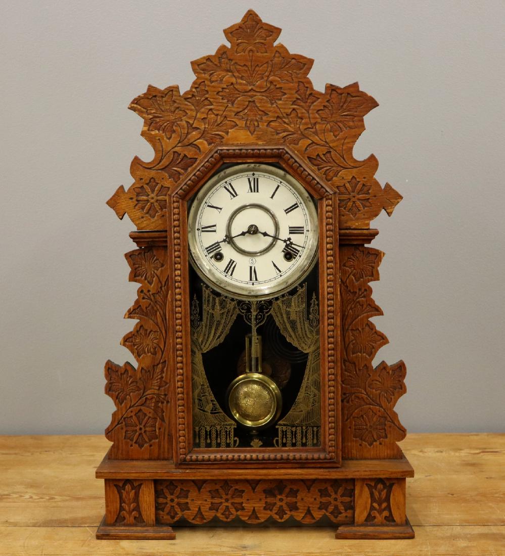 Seth Thomas kitchen clock: An early 20th century Seth Thomas kitchen shelf clock. 8-day time and strike movement with a papered metal dial. Oak case with pressed carved design. Old finish with some wear. Running when cataloged.