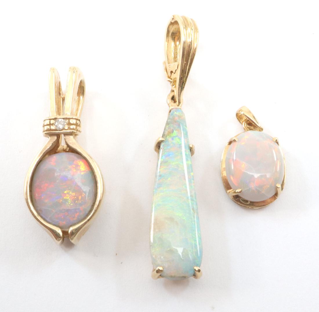 3 Boulder Opal Pendants: Three Yellow Gold & Boulder Opal Pendants. All three are boulder opal with red/orange play of color. Two are stamped "14K", the other is unmarked. The unmarked pendant has some damage to the gold and