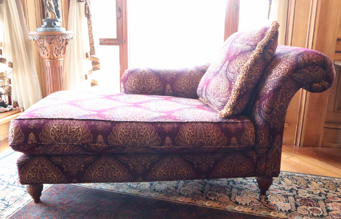 Baker Chaise Lounge: A Baker Milling Road Collection Chaise Lounge. Upholstered in a merlot color with gold medallion repetitious pattern, with one matching pillow. Some fading to the upholstery. 67" x 32" x 33" h. ESTIMA