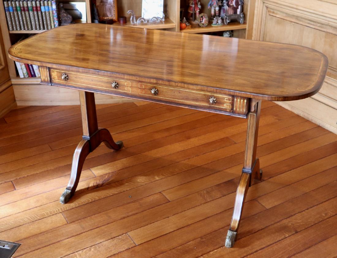 Theo. Alexander Library Table: A Theodore Alexander Library Table. Oval table with 2 faux drawers at one side and 2 functioning drawers at the other; featuring brass knobs and star form escutcheons, with Brass inlaid detail. Slight
