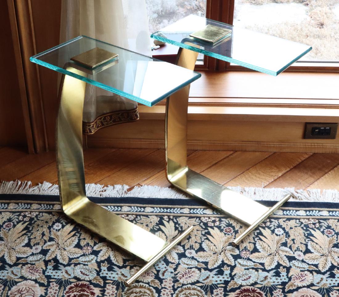 Pr. Glass & Metal End Tables: A Pair of Contemporary Glass & Metal End Tables. Each having a rectangular glass top with gold tone metal bases. Wear and light scratches to the metal surface. 16" x 8" x 22 1/2" h. ESTIMATE $200-300