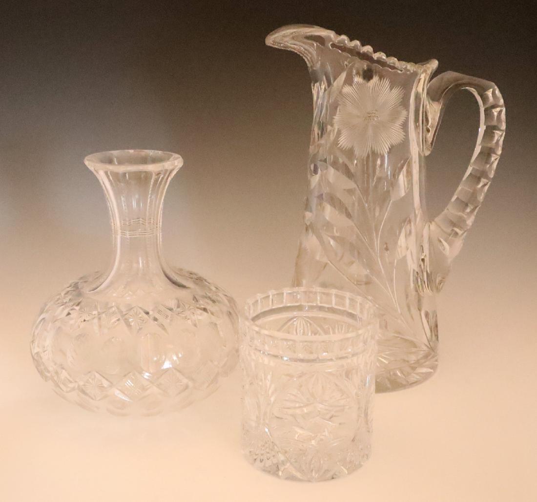 3 pcs Glass Tableware: Three Pieces of Glass Tableware. Including 1 pressed glass beaker, 1 cut glass decanter (no stopper), and 1 cut glass pitcher. All are unmarked. Light wear and surface scratches overall, the beaker ha