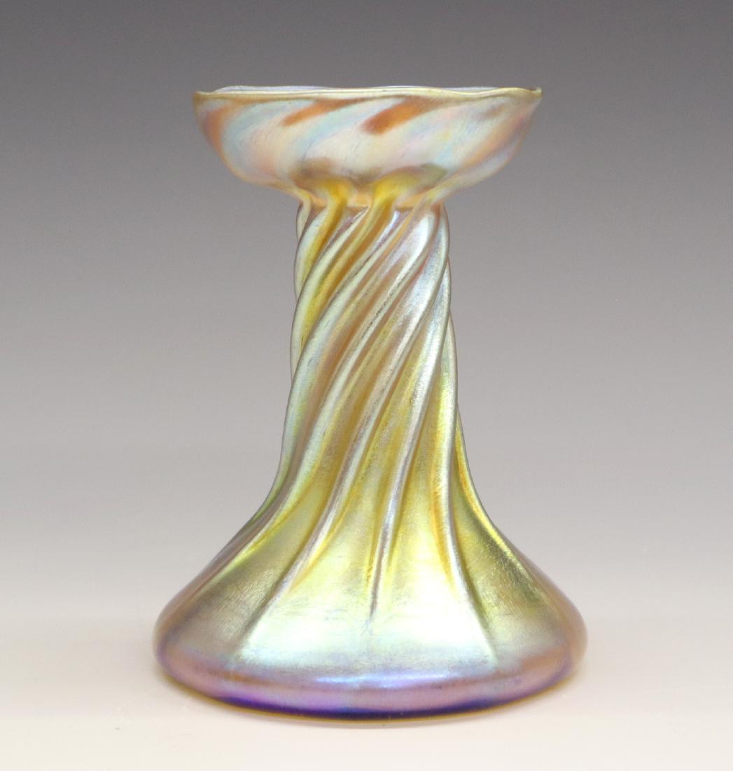 Tiffany Favrile Glass Candlestick: An Early 20th Century Tiffany Favrile Glass Candlestick. Iridescent glass with twisted design. Signed "LCT" at the underside. Light wear overall. 5" high. ESTIMATE $200-400