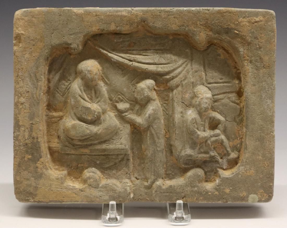 Chinese Tile, Jin Dynasty: A Chinese Jin Dynasty Earthenware Tile. Rectangular form tile depicts an interior setting with three figures; one of which sits, in Lotus position, with one of the other figures attending to them. Unm