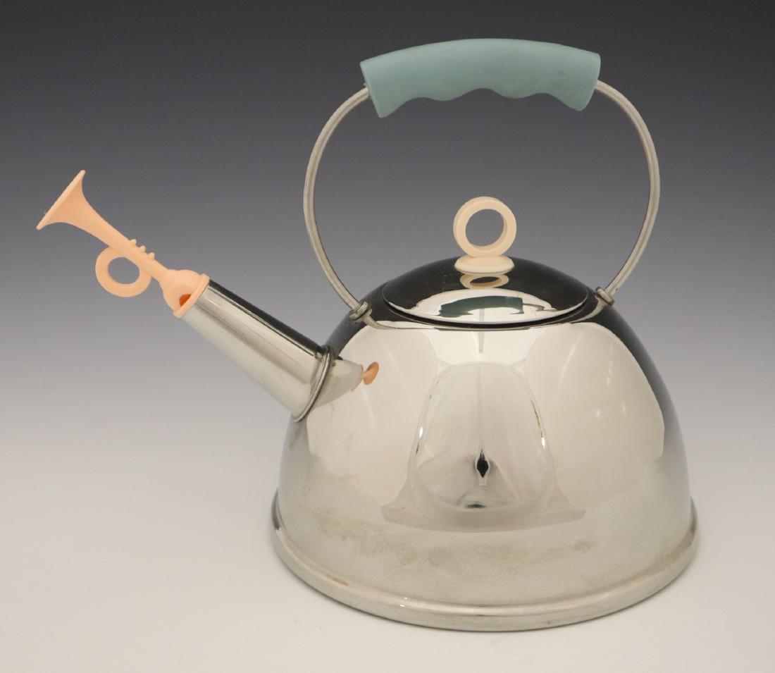 Michael Graves/Alessi Tea Kettle: Michael Graves (American, 1934-2015) For Alessi Tea Kettle. Stainless steel tea kettle with plastic grip, finial, and trumpet spout cover/whistle. Marked at the underside. Light wear. 9" high. ESTIMAT