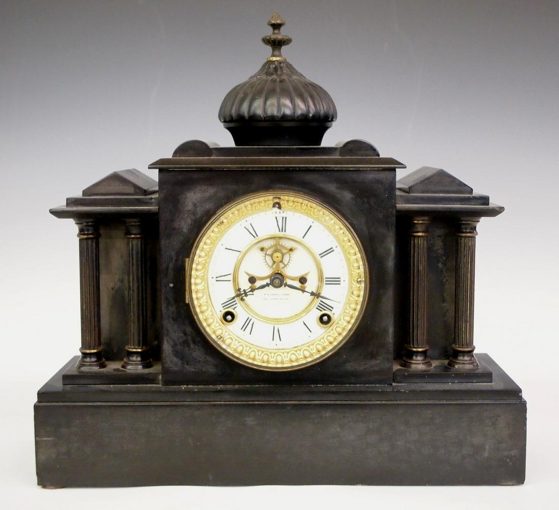Ansonia mantle clock: A late 19th century Ansonia Slate mantle clock. Retailed by "R. A. Jones & Sons, Southend-On-Sea". 8-day time only movement with porcelain dial and visible escapement. Black Slate case with cast dome 