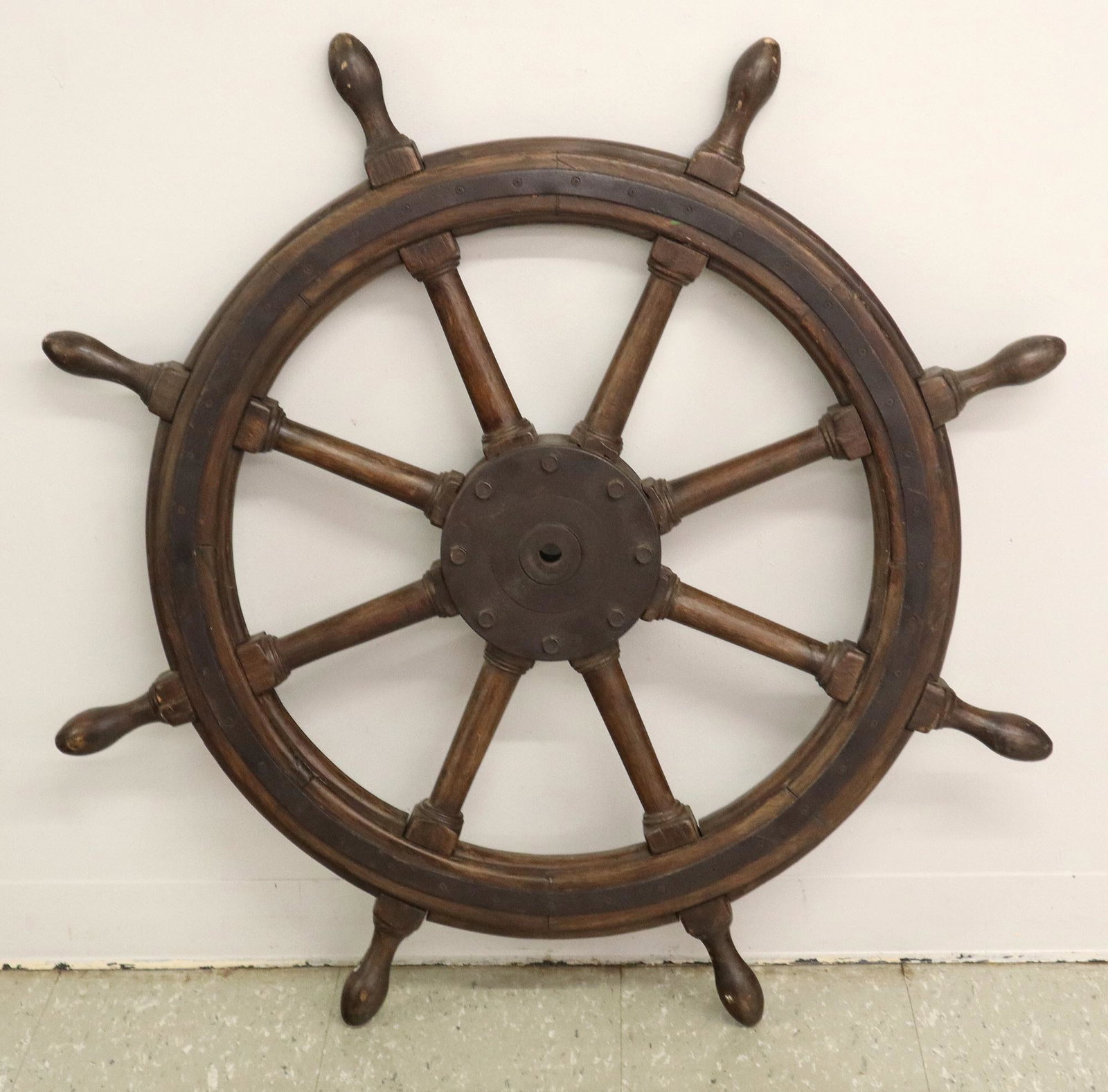 Ship's wheel: A 20th Century Ship's Wheel. Comprised of hard wood (possibly teak) and cast iron hub and rings with green paint remnants. Some wear to the finish, nicks and scratches. 40" diameter. ESTIMATE $200-300