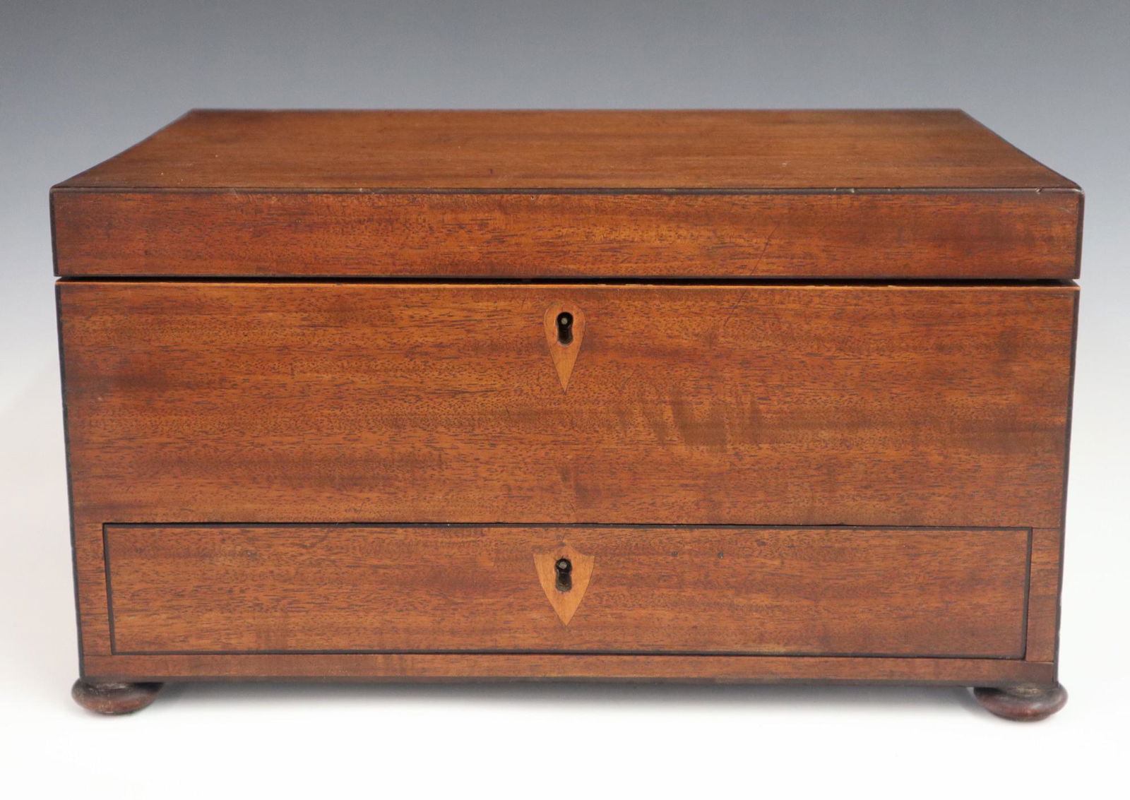 Regency Jewelry Box: An early 19th century British Regency Period jewelry box. Mahogany with Ebony stringing, Brass handles and flattened ball feet. Features a lift top with fitter tray and lower drawer. Older finish with