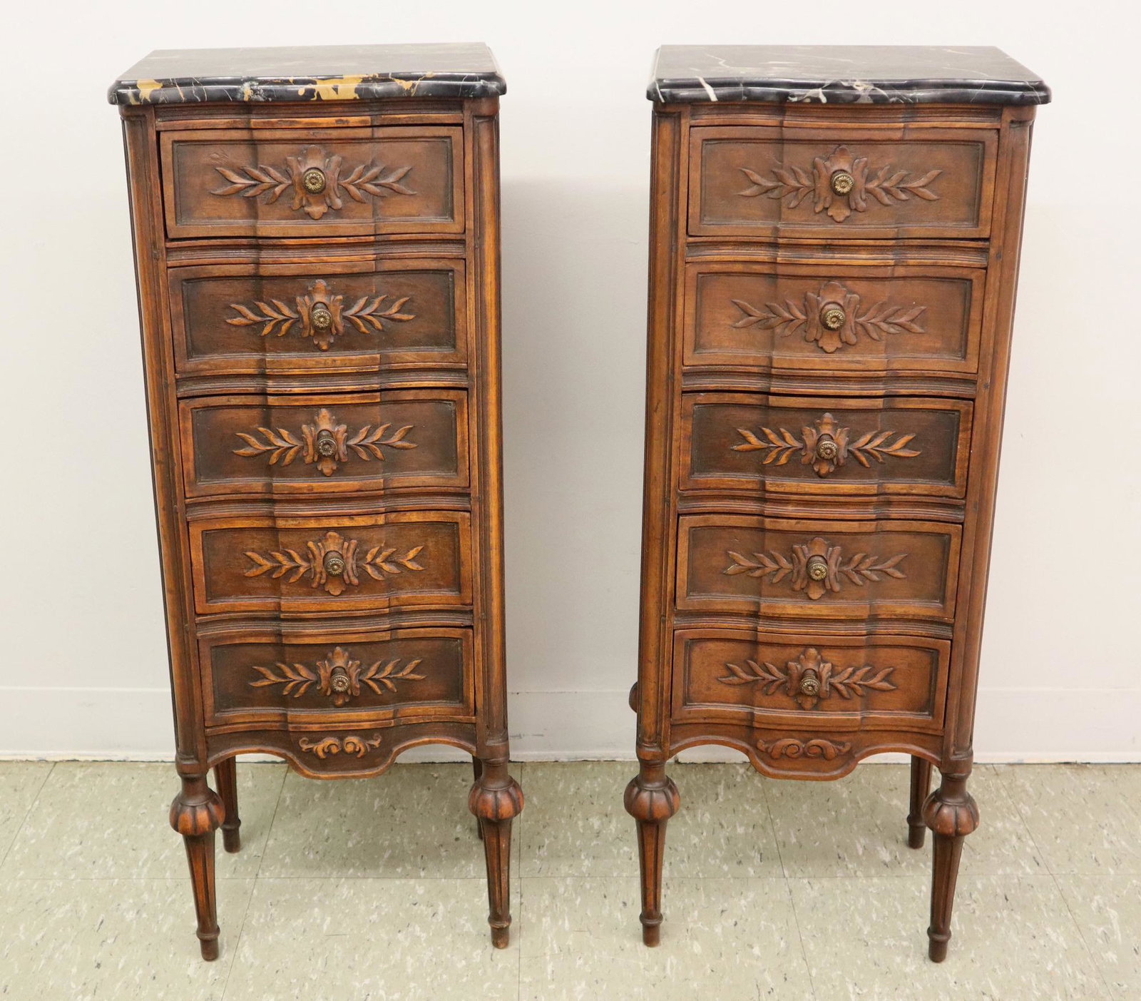 Pr French Nightstands: A pair 1920's Louis XVI style French nightstands. Carved Walnut with inset marbles and tall turned legs. Old finish with minor wear, one marble repaired. Each 14 x 11 x 36 1/4" high. ESTIMATE $200-400
