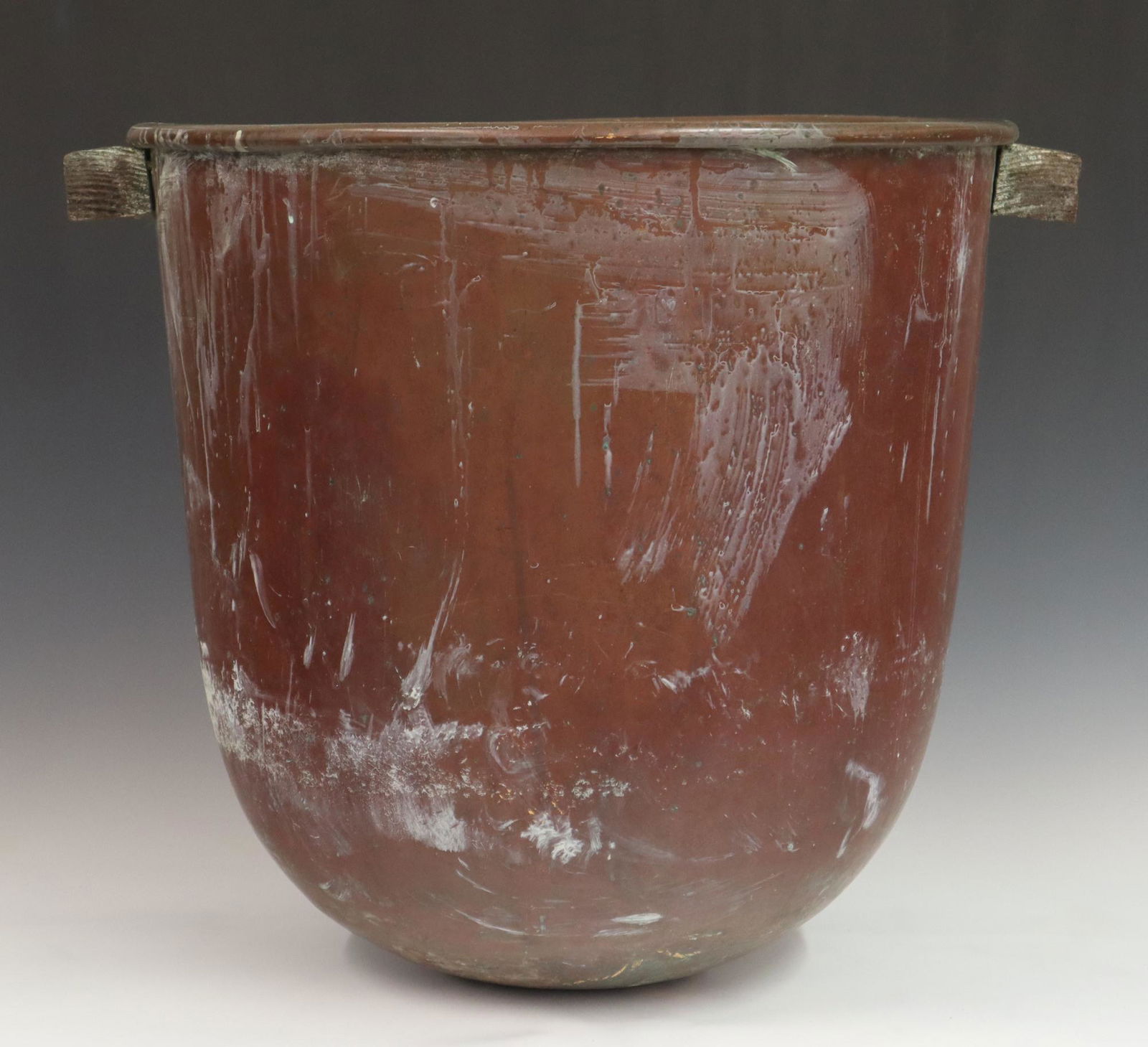 Copper Kettle: A large turn of the century Copper cooking kettle. Dovetailed construction with round bottom and wood handles. Wear and some denting. 18 1/2" high. ESTIMATE $50-100