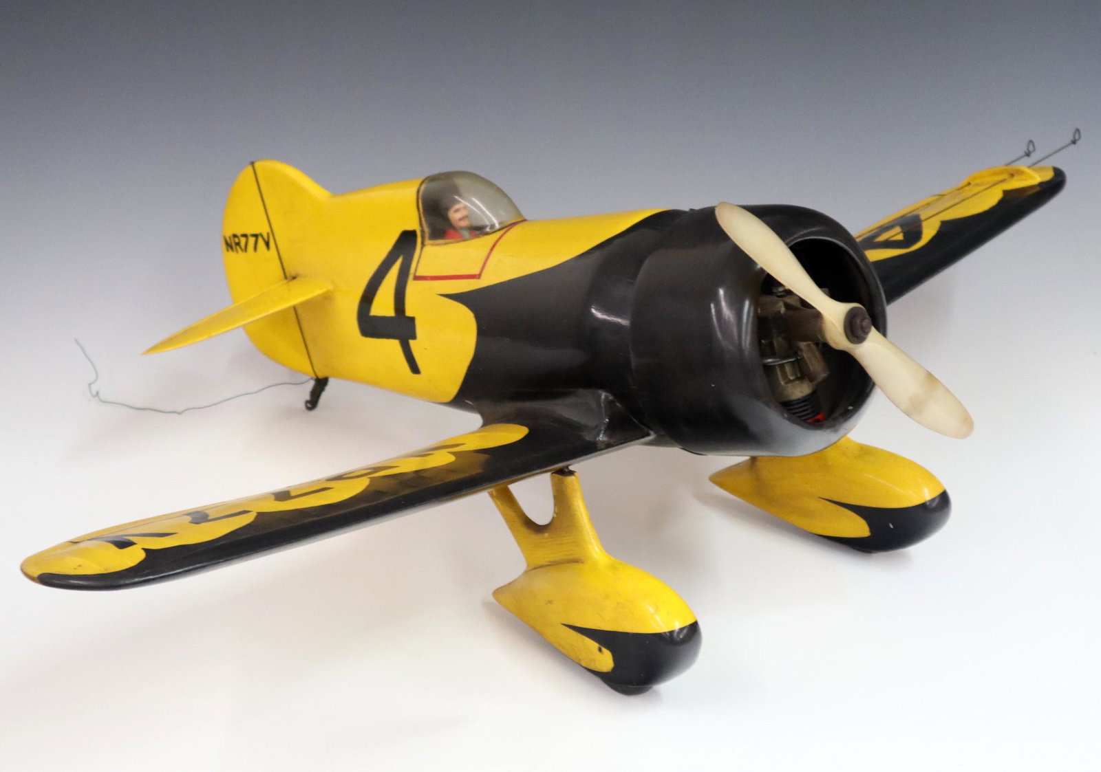 Model Airplane: A 1960's era tether control model airplane with gas engine. Wooden frame with painted Yellow skin and Black detail. Some wear. 31" wingspan. ESTIMATE $100-200