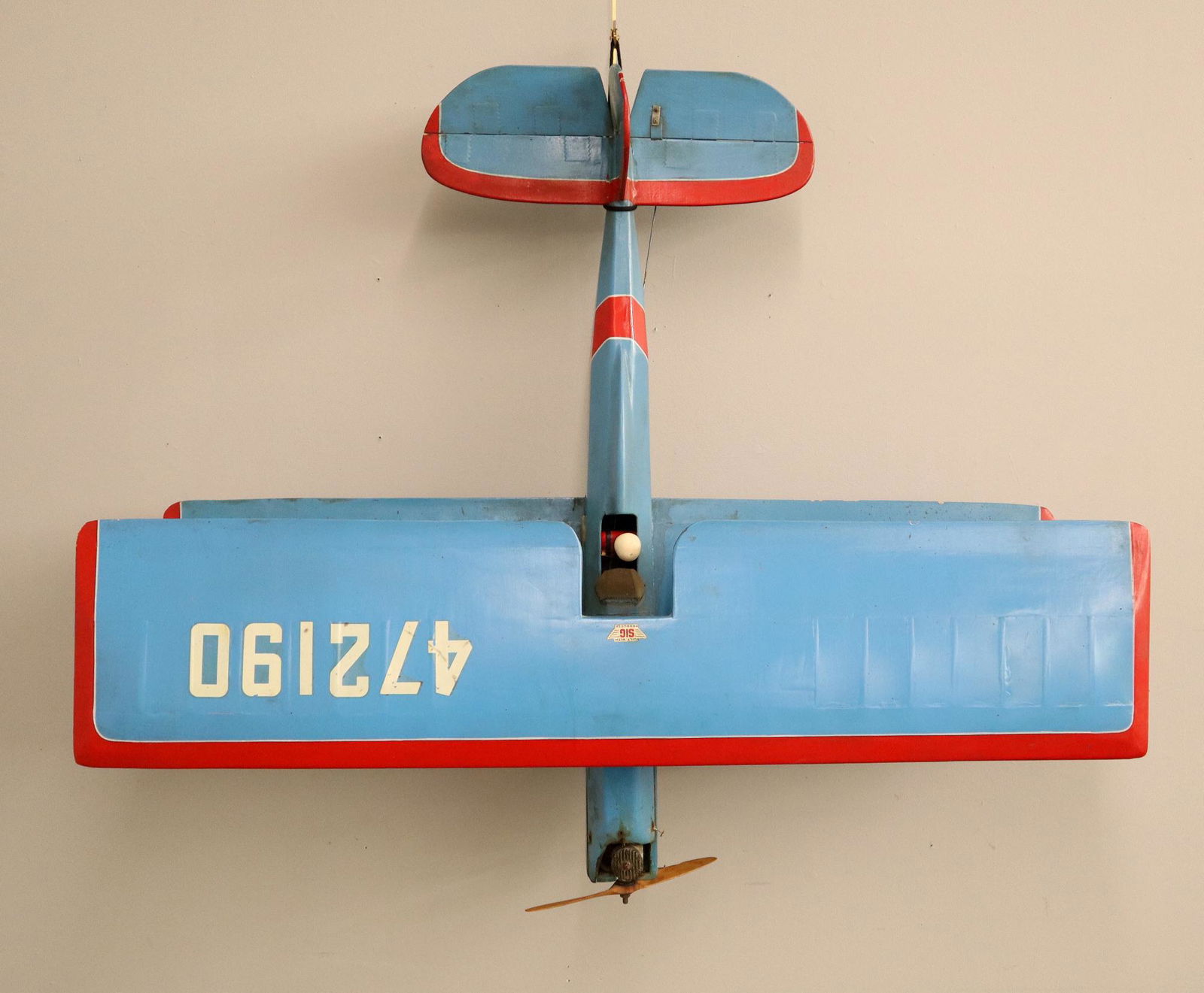 Model Airplane: A 1960's era tether control model airplane with gas engine. Bi plane with wooden frame and painted medium Blue skin and Black detail. Some wear, small tears in skin. 45 1/2" wingspan. ESTIMATE $100-20