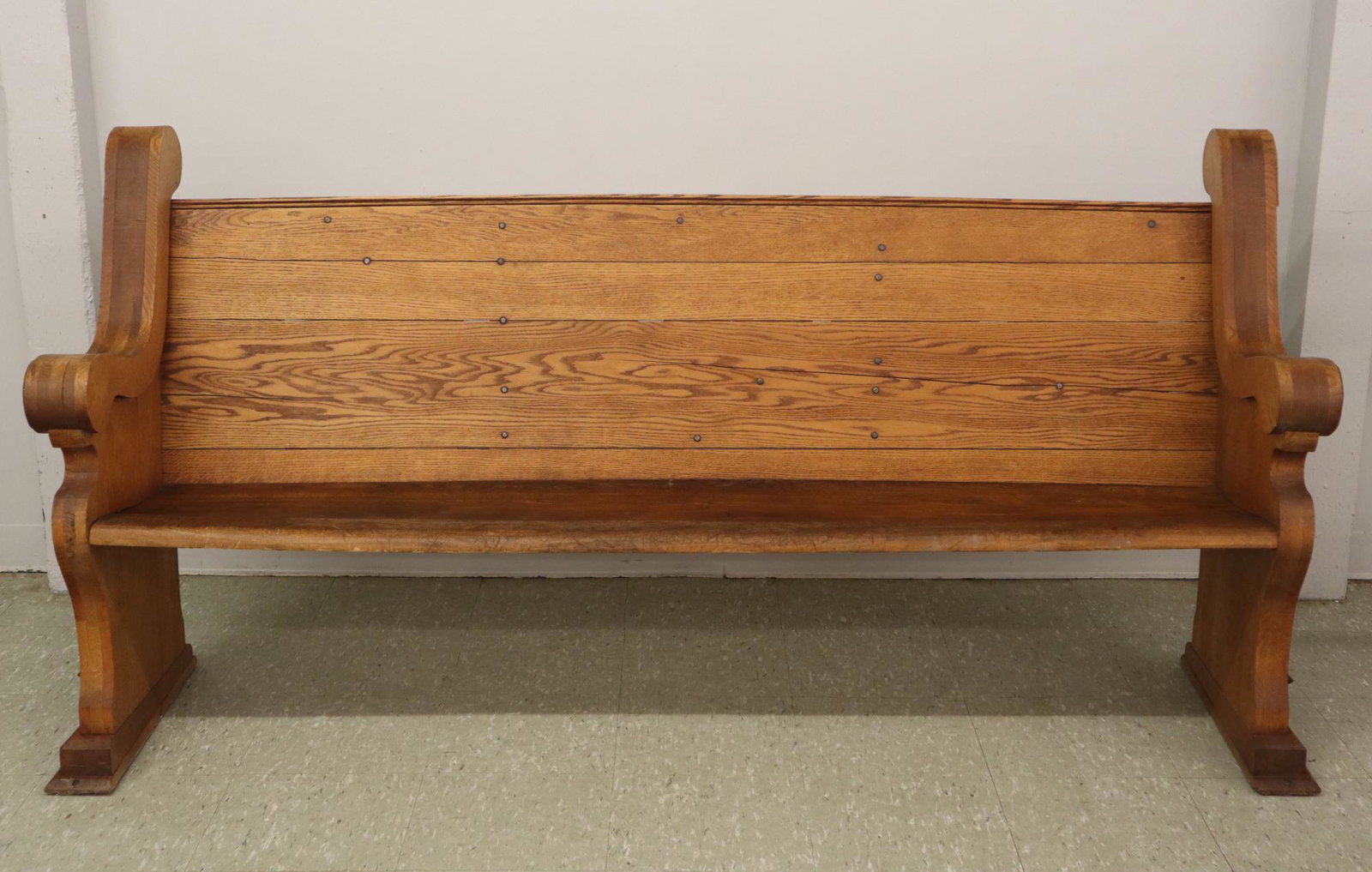 Oak Church Pew: A turn of the century Oak church pew. Curved back and seat with Gothic style carved ends. Older refinishing with minor wear, some joint shrinkage. 78" long x 39" high. ESTIMATE $100-200