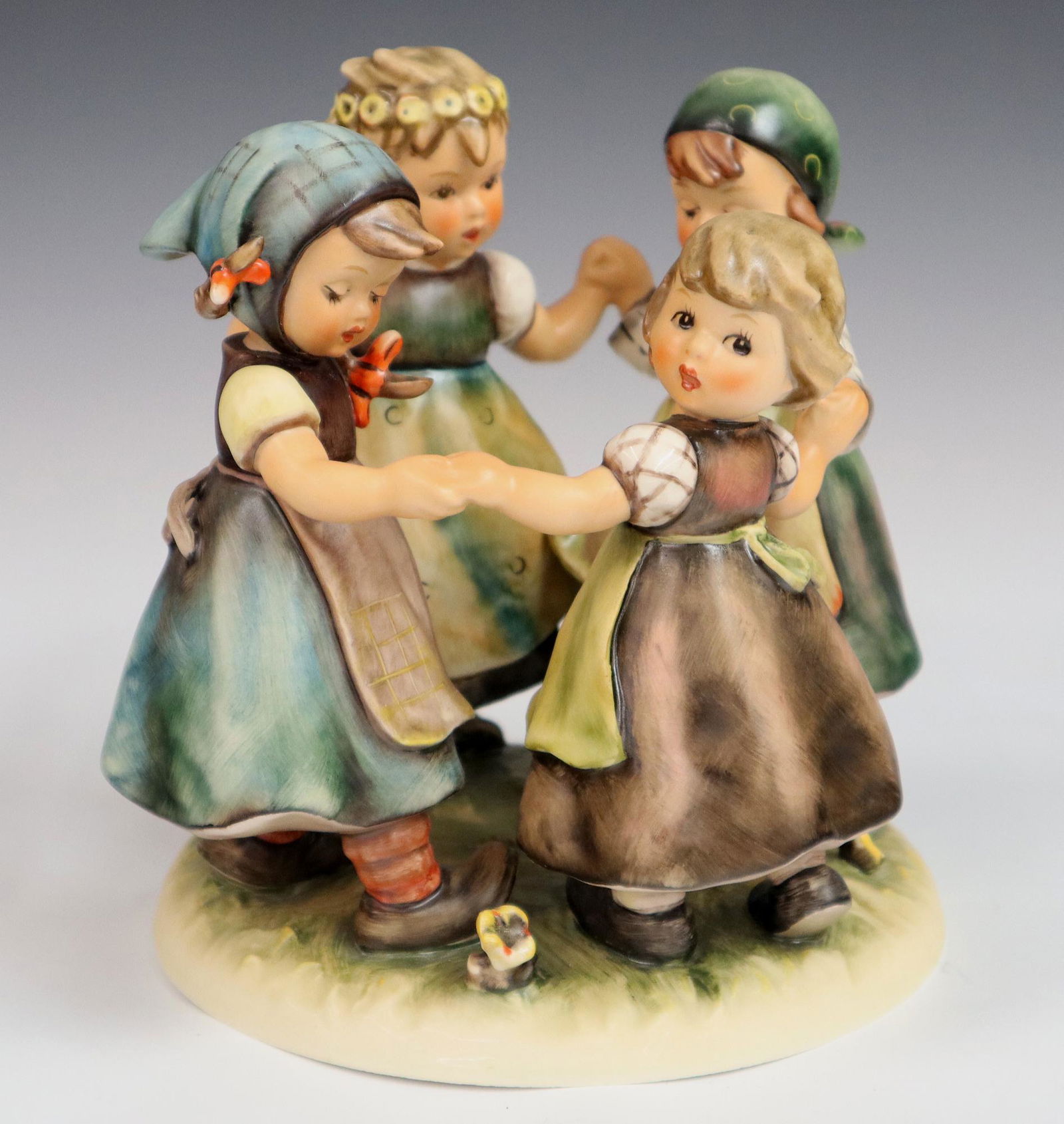Goebel/Hummel Figure: A Goebel/Hummel porcelain figure with hand painted decoration. "Ring Around The Rosie" #348. Printed and impressed marks. Slight wear to paint, crazing under base. 7" high. ESTIMATE $200-300