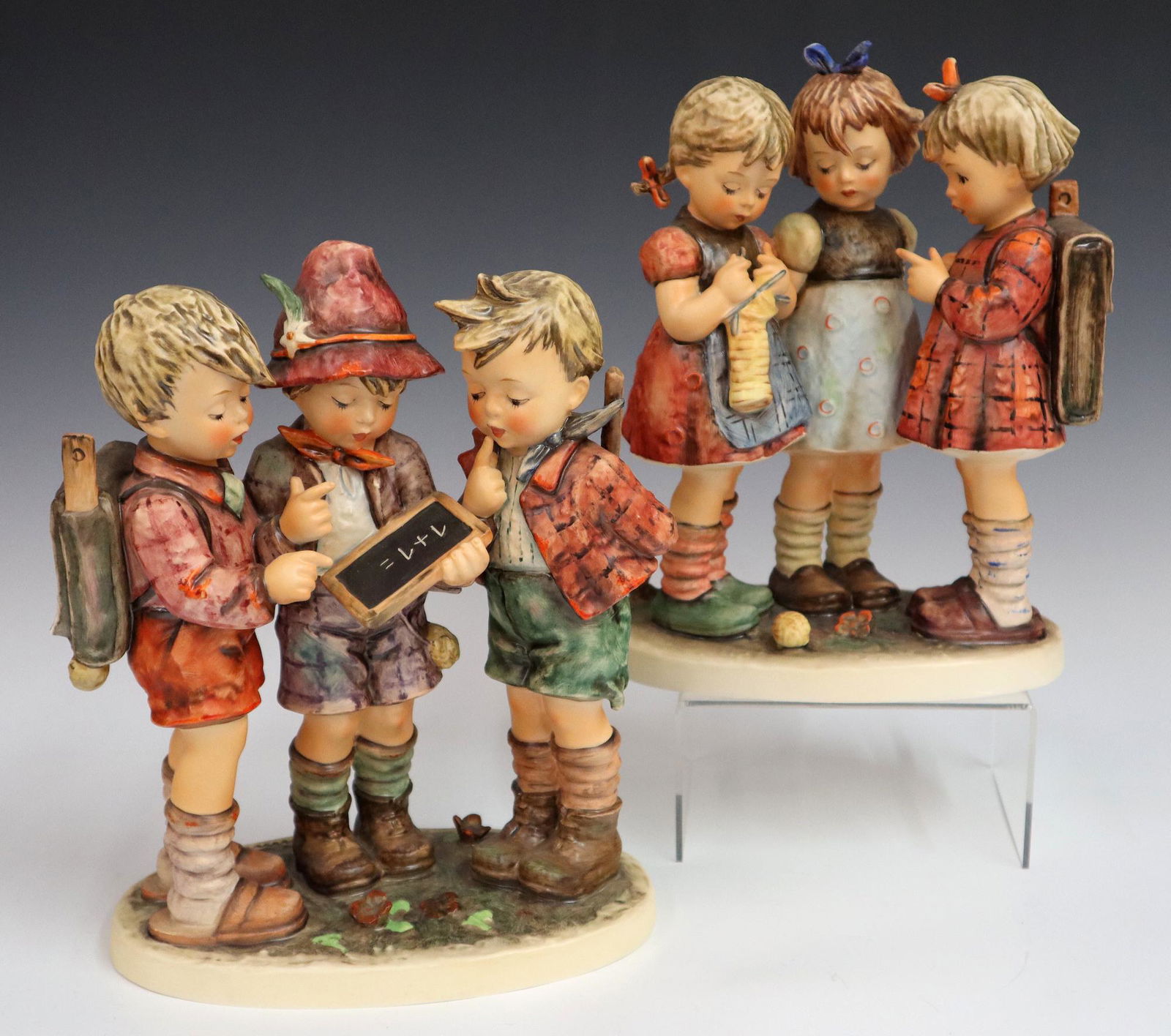 2 Goebel/Hummel Figures: Two Goebel/Hummel porcelain figures with hand painted decoration. "School Boys" #177 and "School Girls" #170. Printed and impressed marks. Slight wear to paint. Each 9" high. ESTIMATE $200-300
