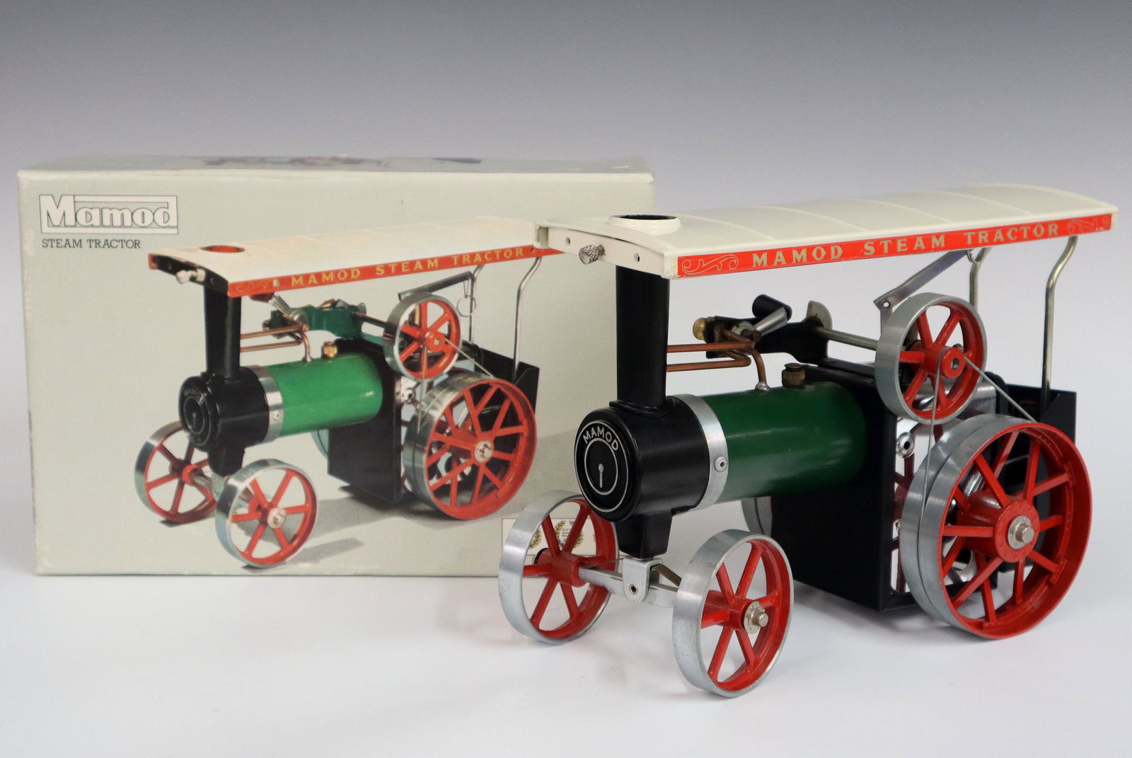 Mamod Steam Tractor: A 1990's Mamod scale model team powered tractor. Painted metal construction, in the original box. Minor surface wear, no damage, some wear on box. 10" long. ESTIMATE $50-100